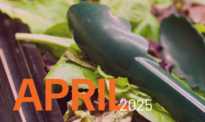 Mixed greens salad with black plastic serving tongs on top, with the words April 2025 written over the image in orange and white text