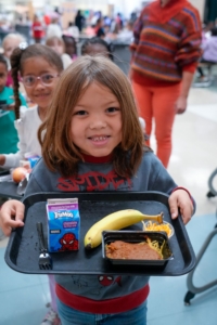 A child holding a school lunch tray