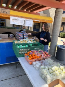 A woman selects food at an outdoor food stand at Fresno USD