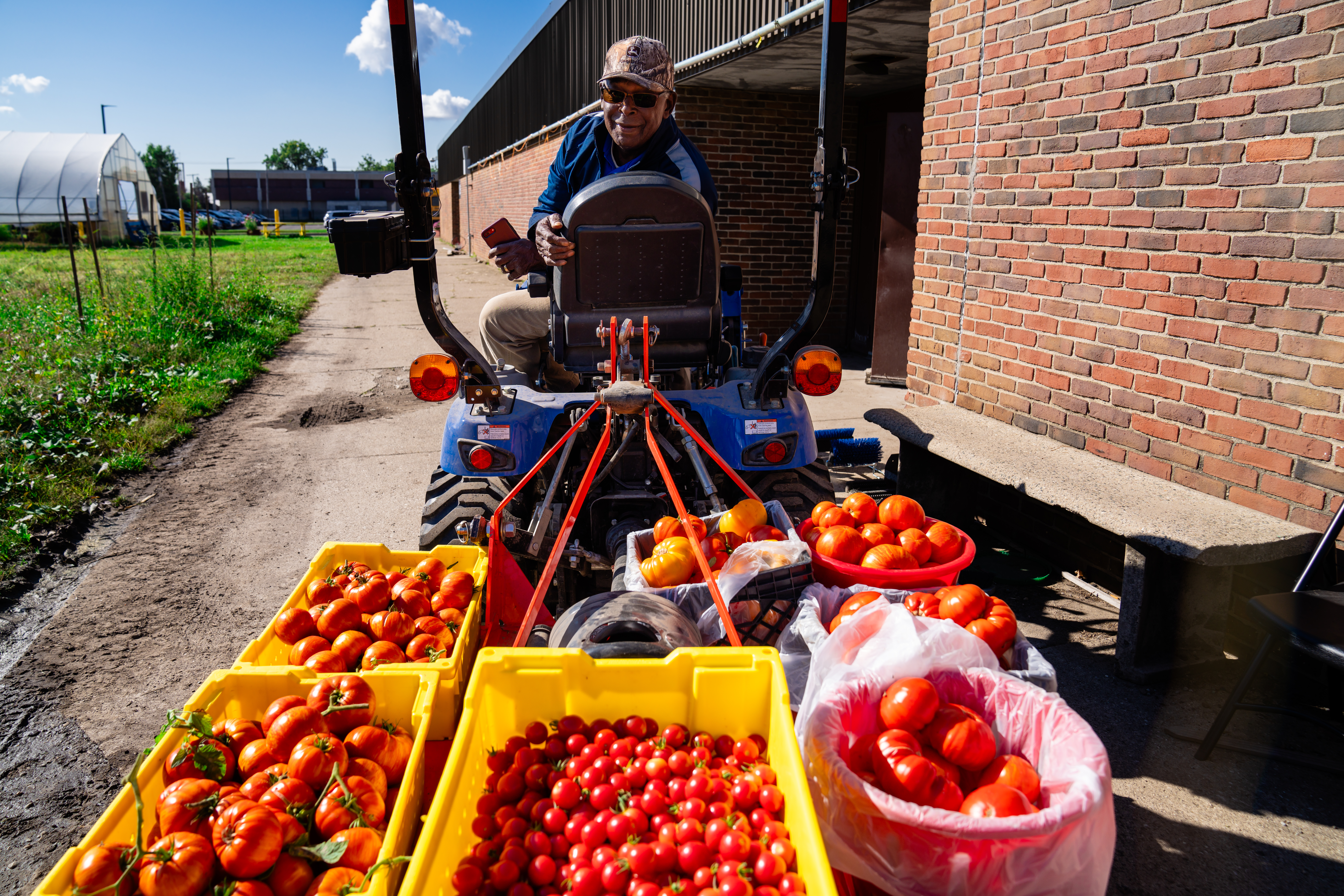 A farmer hauls tomatoes with a tractor at Drew Farm in Detroit, Michigan