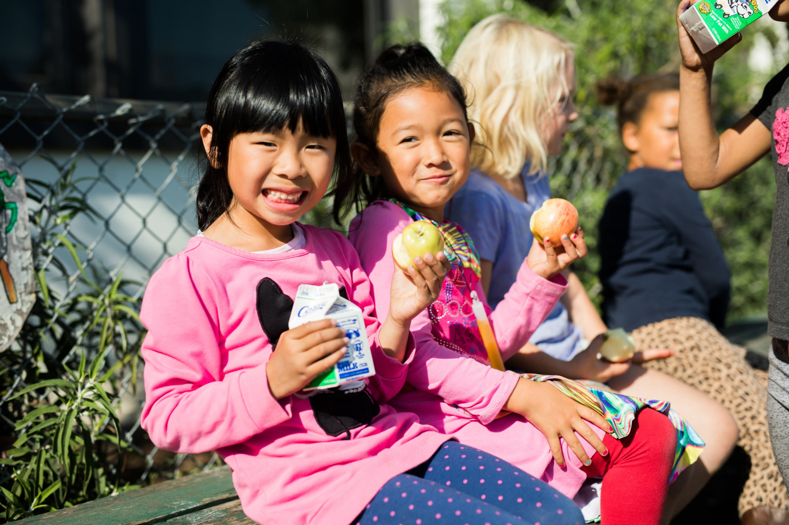 110217_SFUSD-338 (2) Two children eat apples on a school bench