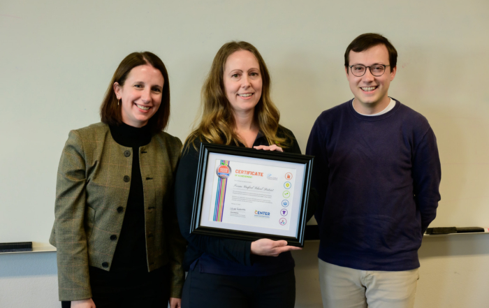 Alexa Delwiche, Amanda Harvey, and Peter Cohen display a certificate of achievement