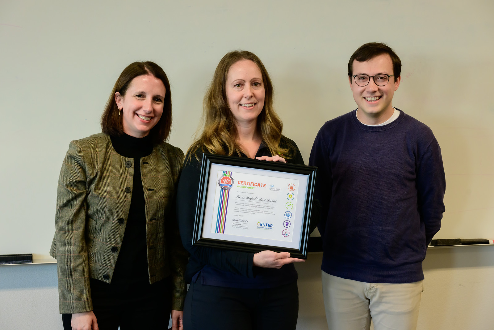 Alexa Delwiche, Amanda Harvey, and Peter Cohen display a certificate of achievement