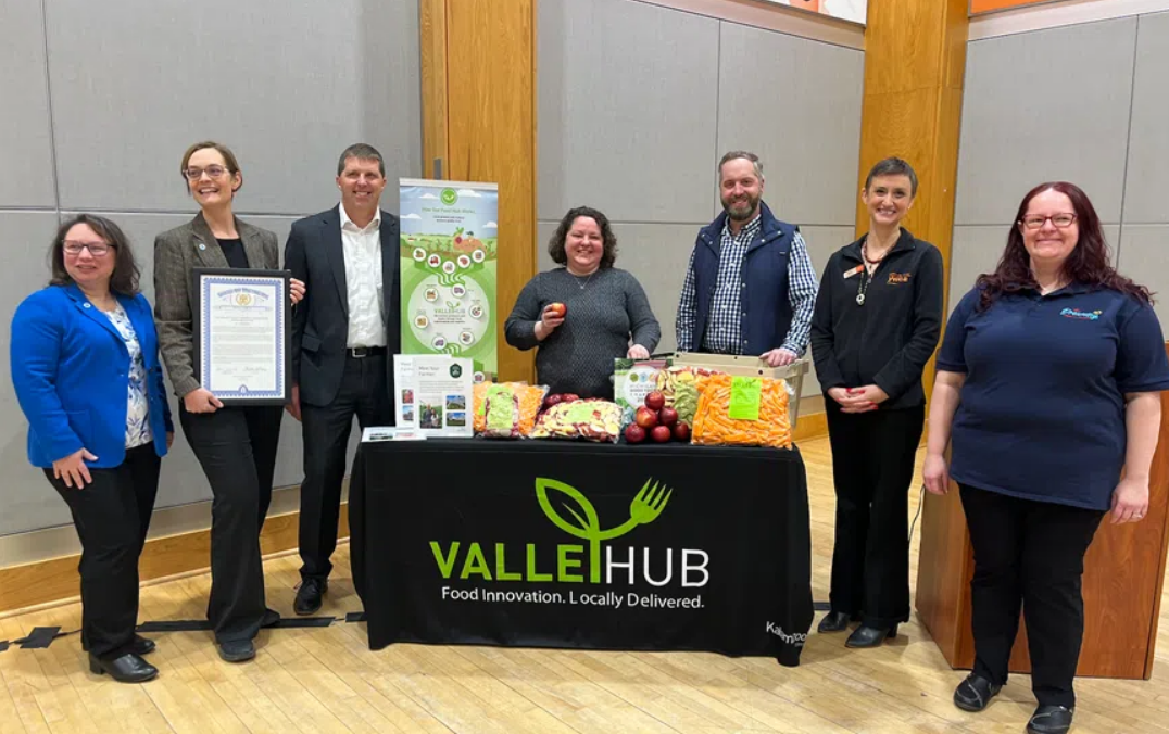Kalamazoo, Michigan area food systems leaders stand by a ValleyHub table at a celebratory event
